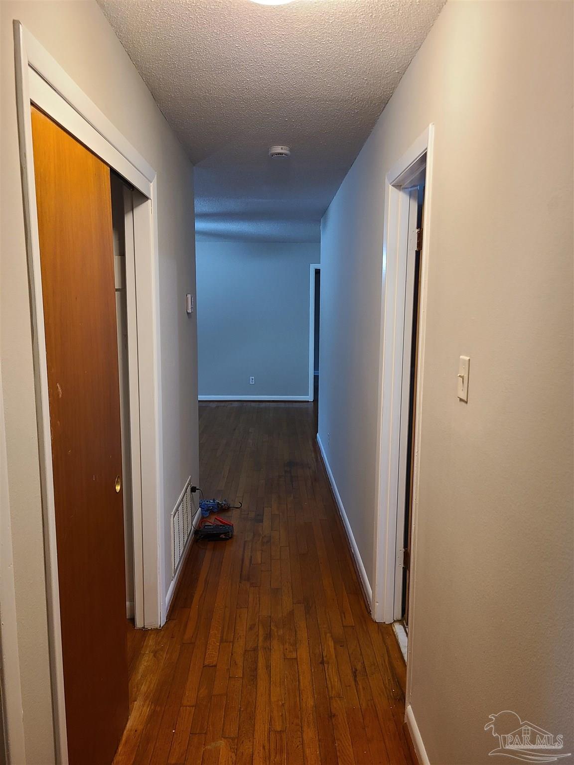 7758 Kipling Street Pensacola, FL 32514 - Photo 17 of 23 a view of a hallway with wooden floor and staircase