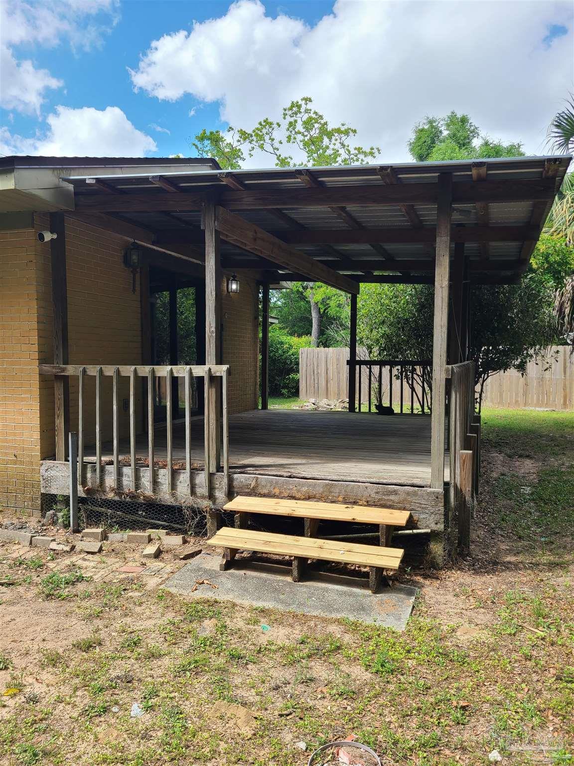 7758 Kipling Street Pensacola, FL 32514 - Photo 18 of 23 a backyard of a house with wooden floor a yard and outdoor seating