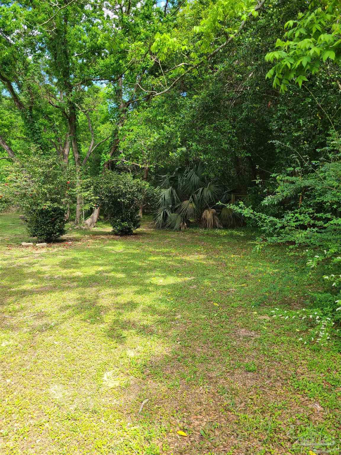 7758 Kipling Street Pensacola, FL 32514 - Photo 20 of 23 a view of a green field with plants in front of it