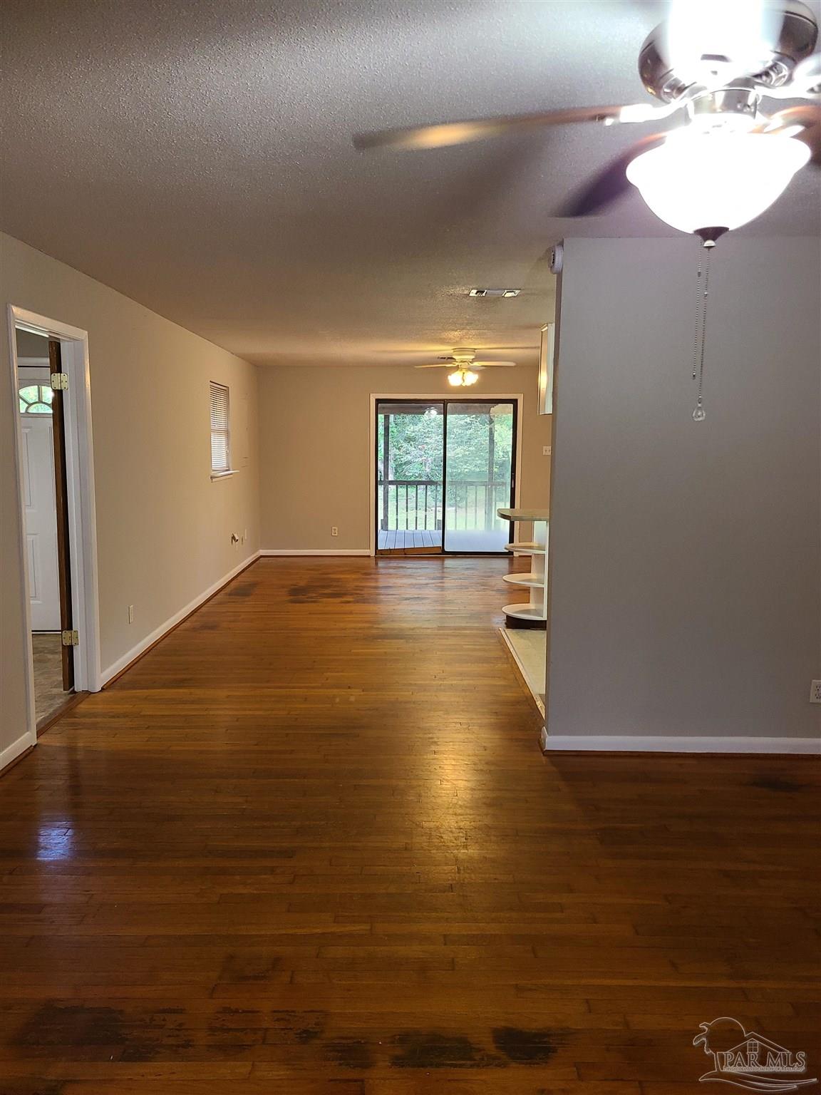 7758 Kipling Street Pensacola, FL 32514 - Photo 2 of 23 a view of an empty room with window and wooden floor