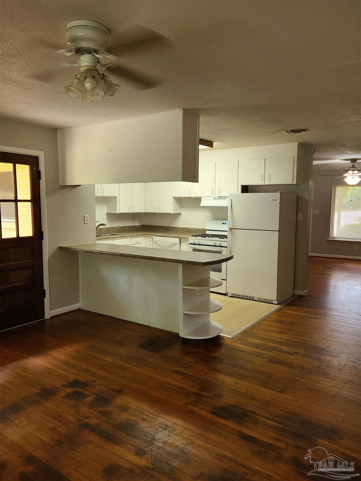 7758 Kipling Street Pensacola, FL 32514 - Photo 9 of 23 a kitchen with kitchen island a sink appliances and cabinets