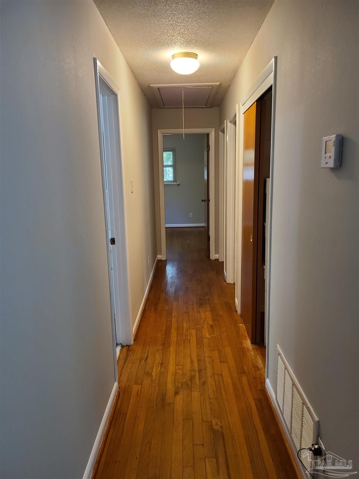 7758 Kipling Street Pensacola, FL 32514 - Photo 10 of 23 a view of a hallway with wooden floor