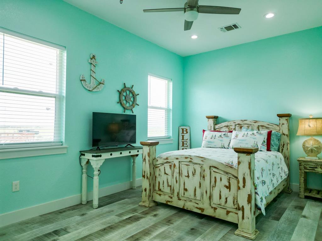 904 Polk Avenue Port O'Connor, TX 77982 - Photo 11 of 40 a bedroom with a bed and a flat screen tv