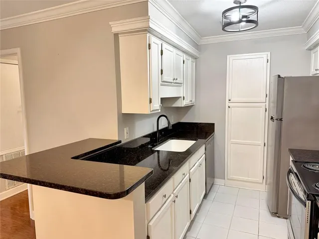 a view of a kitchen with a sink a refrigerator and cabinets