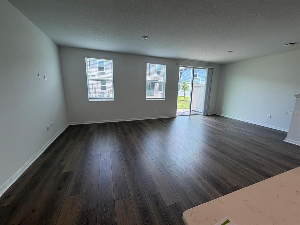 4244 Ranch House Road St. Cloud, FL 34772 - Photo 6 of 34 a view of an empty room with wooden floor and a window