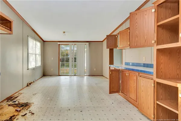 a view of an empty room with window and cabinet