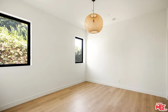 a view of a room with wooden floor and a window