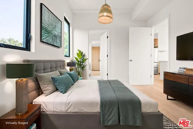 a bedroom with a bed and a potted plant