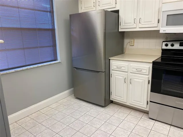 a kitchen with stainless steel appliances a refrigerator and cabinets