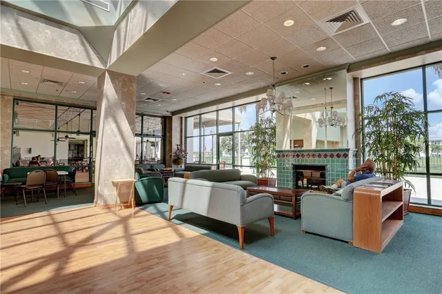 a living room with furniture a fireplace and a floor to ceiling window