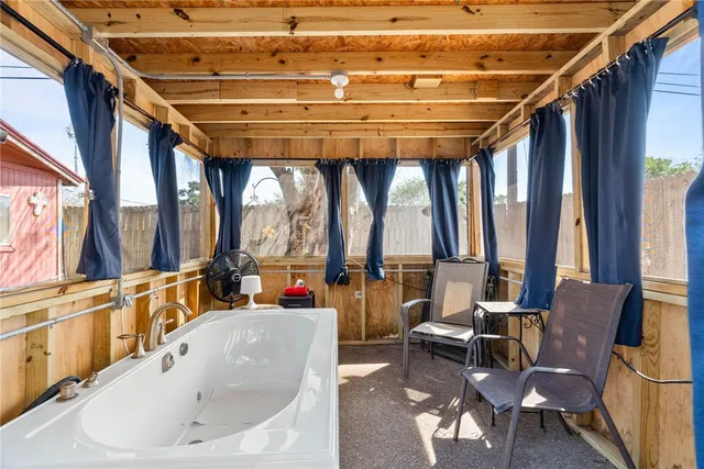 a bathroom with a tub and a large window