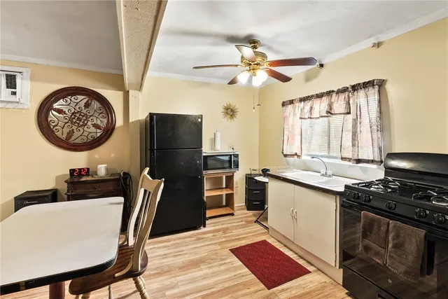 a kitchen with stainless steel appliances granite countertop a stove a refrigerator a dining table and chairs