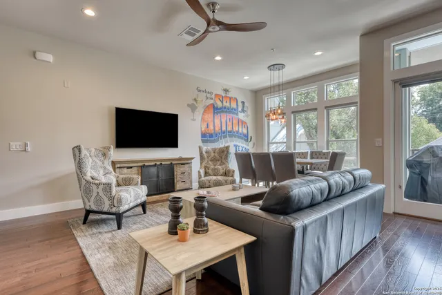 a living room with furniture a flat screen tv and a large window