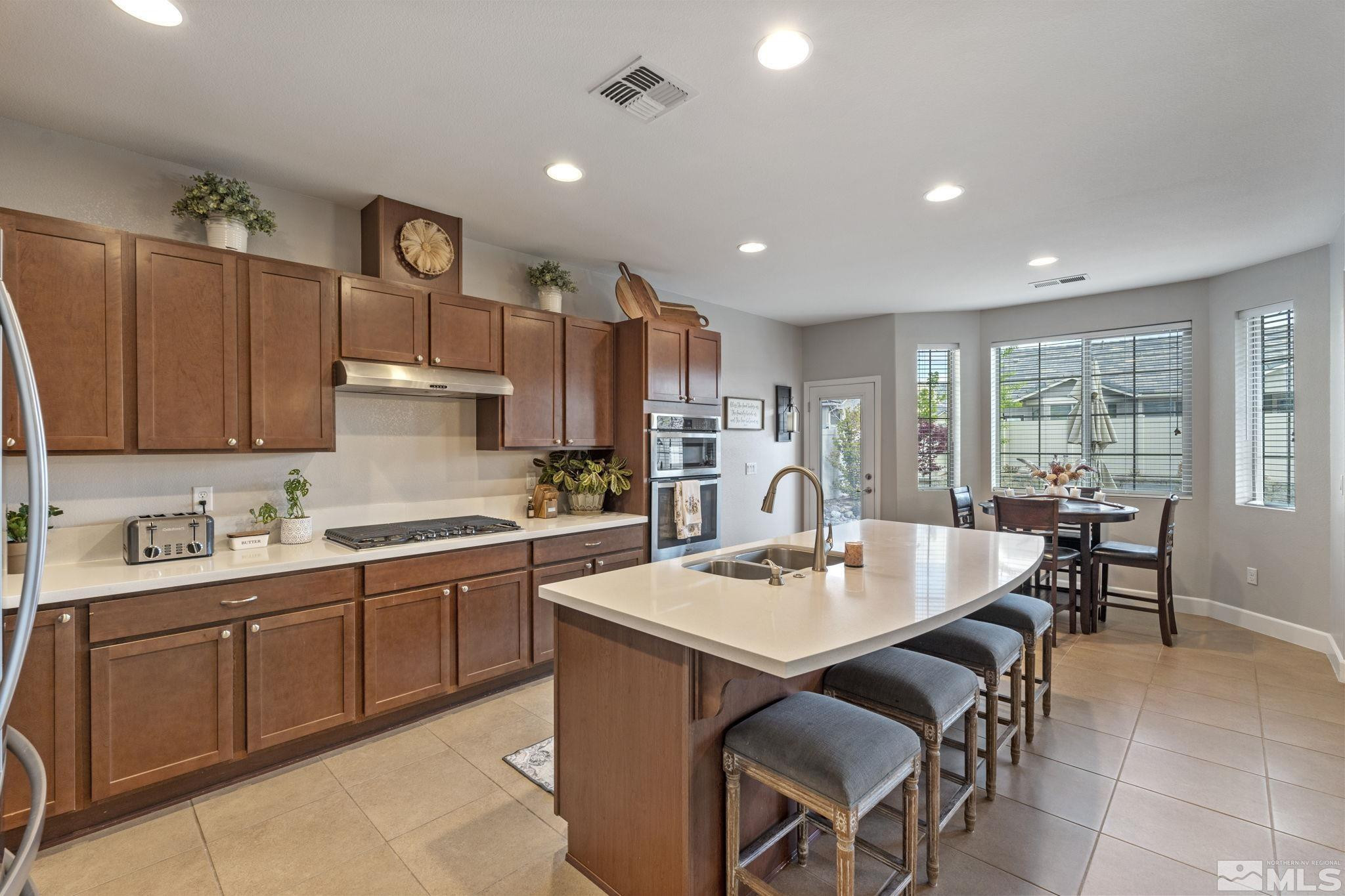 508 Alpine Rose Ct. Reno, NV 89521 - Photo 13 of 39 a kitchen with a dining table chairs and white appliances