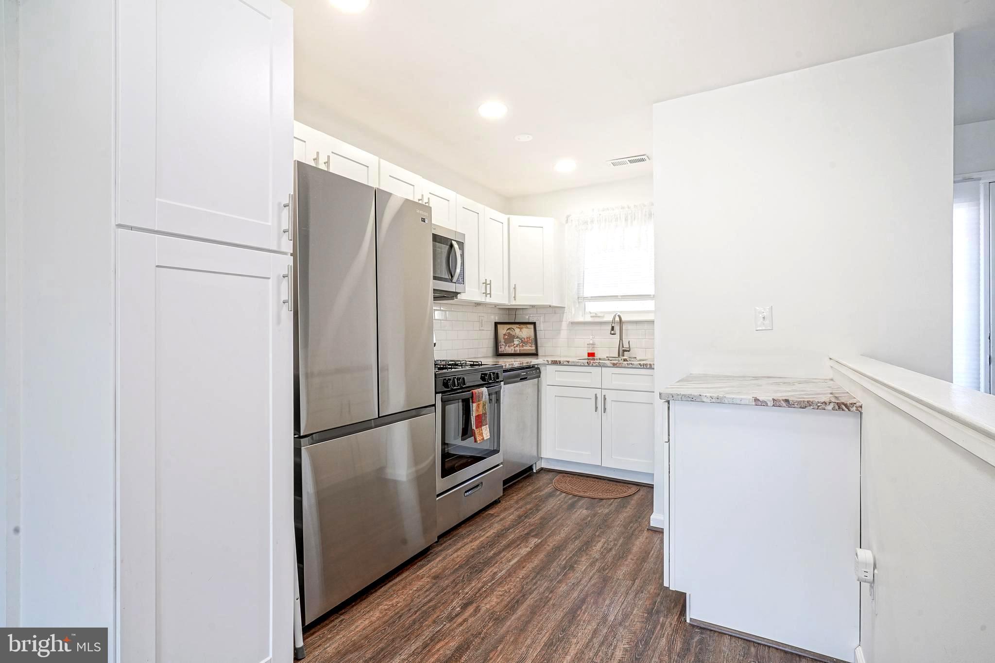 5 Via Cascata Drive Clementon, NJ 08021 - Photo 8 of 26 a kitchen with a refrigerator stainless steel appliances wooden floor and cabinets