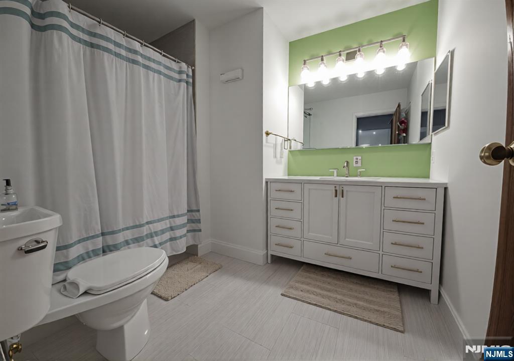 50 Euclid Avenue, Unit 3B Hackensack, NJ 07601 - Photo 8 of 16 a bathroom with a granite countertop sink toilet and mirror