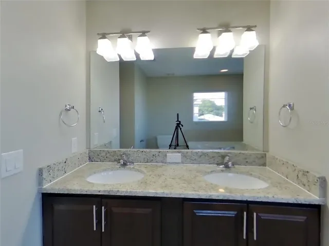 a bathroom with a granite countertop sink a large mirror and a vanity