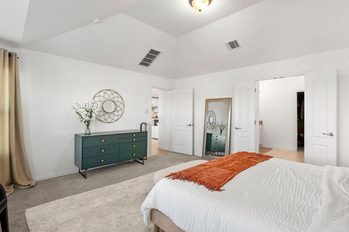 463 Oleander Loop Buda, TX 78610 - Photo 13 of 34 Bedroom with lofted ceiling and light colored carpet