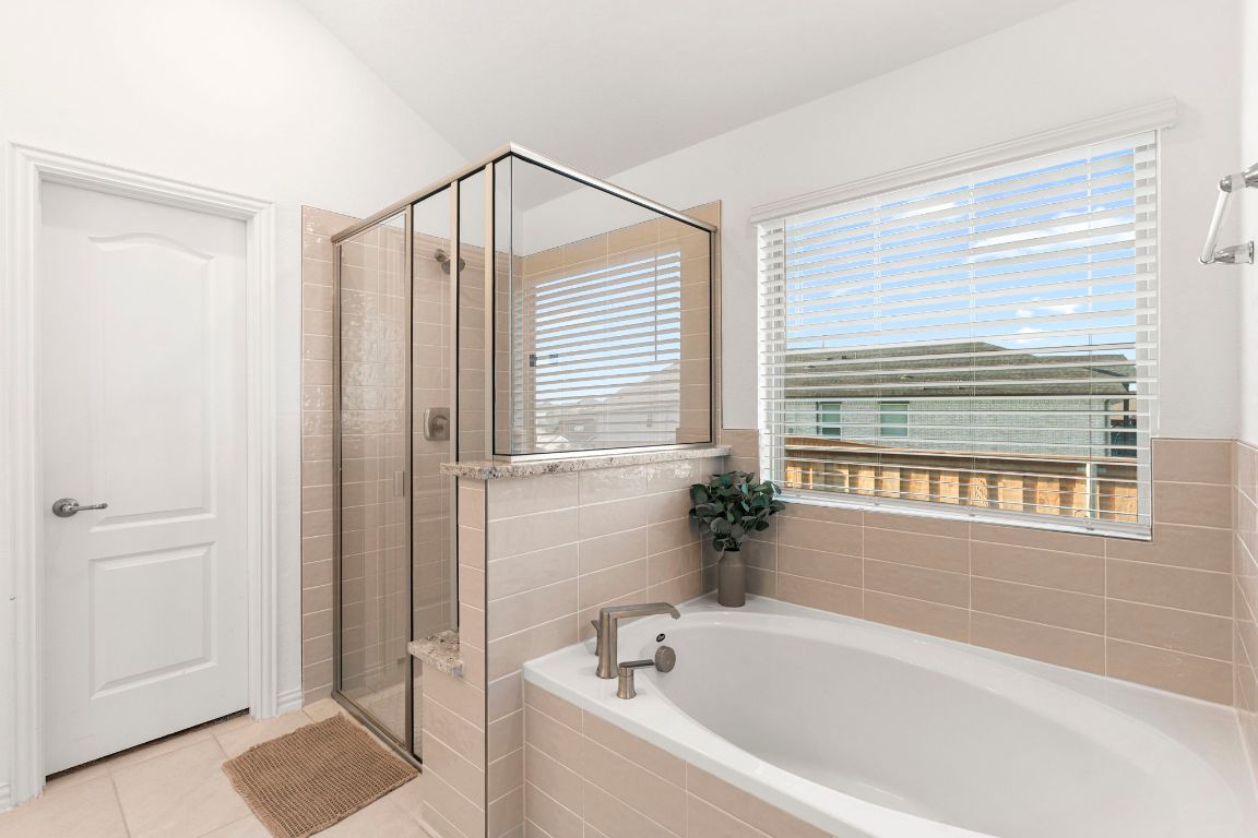 463 Oleander Loop Buda, TX 78610 - Photo 15 of 34 Full bath featuring a shower stall, a bath, and tile patterned flooring