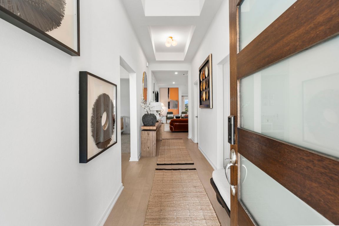 463 Oleander Loop Buda, TX 78610 - Photo 2 of 34 Corridor with light wood-style flooring and a raised ceiling