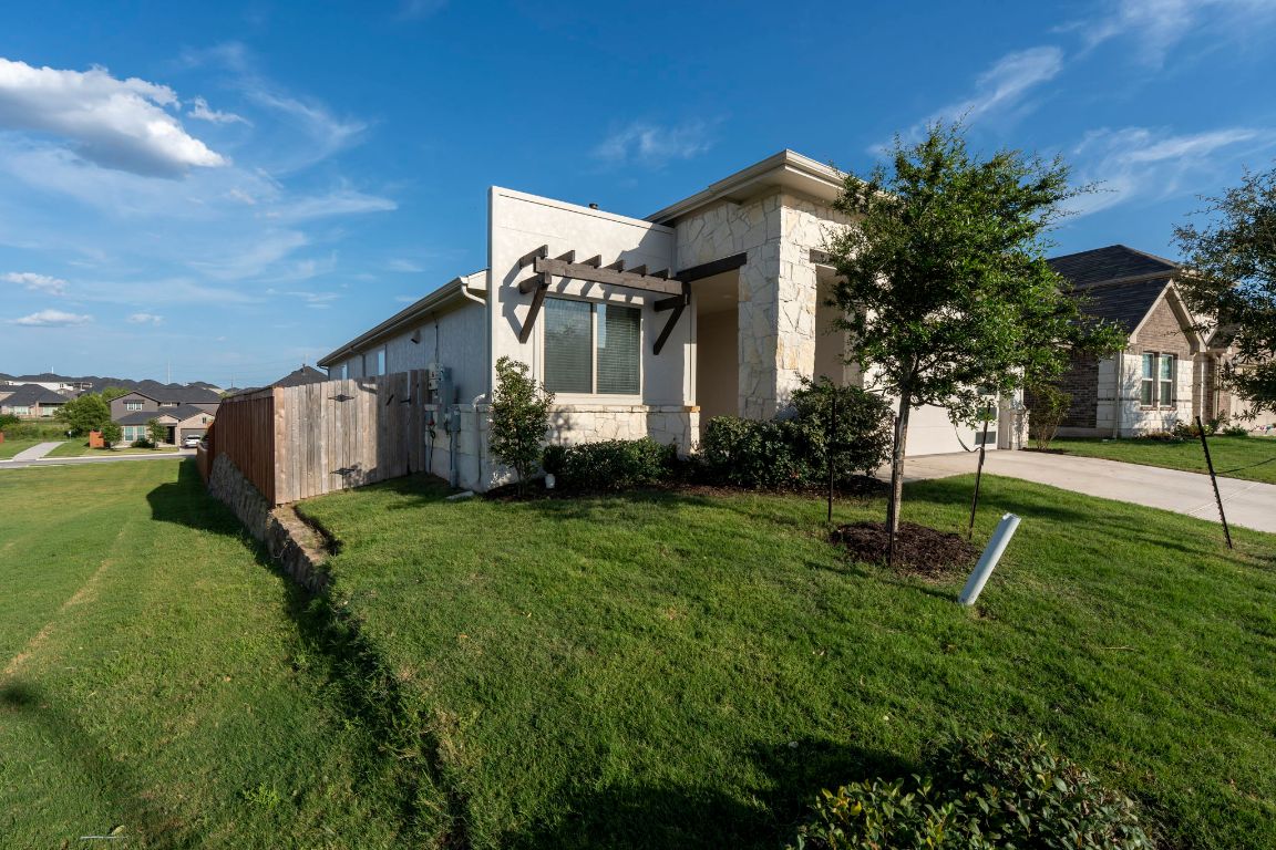463 Oleander Loop Buda, TX 78610 - Photo 26 of 34 View of home's exterior featuring stone siding, concrete driveway, and stucco siding