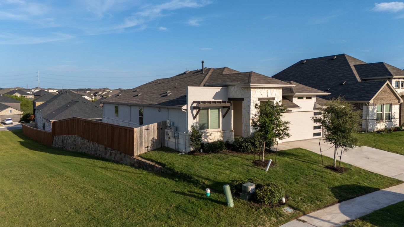 463 Oleander Loop Buda, TX 78610 - Photo 27 of 34 View of front of home featuring stone siding, a residential view, concrete driveway, and a shingled roof