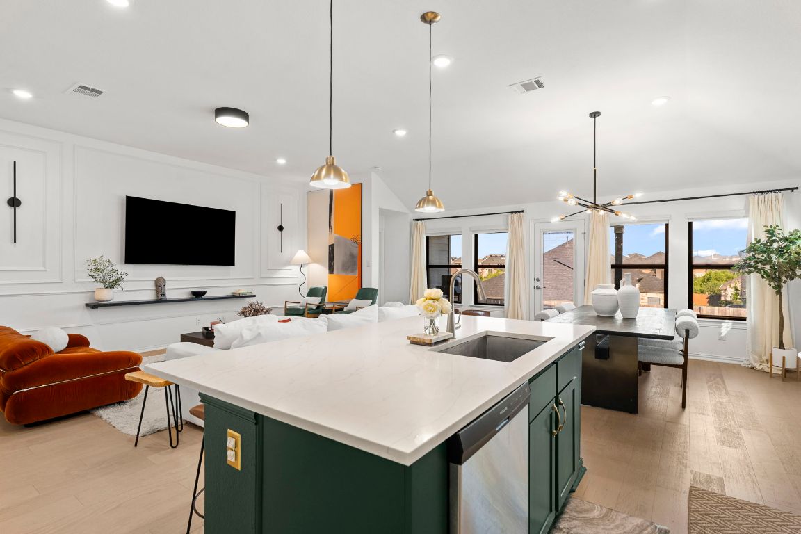 463 Oleander Loop Buda, TX 78610 - Photo 33 of 34 Kitchen with open floor plan, green cabinets, light wood-style floors, dishwasher, and a decorative wall