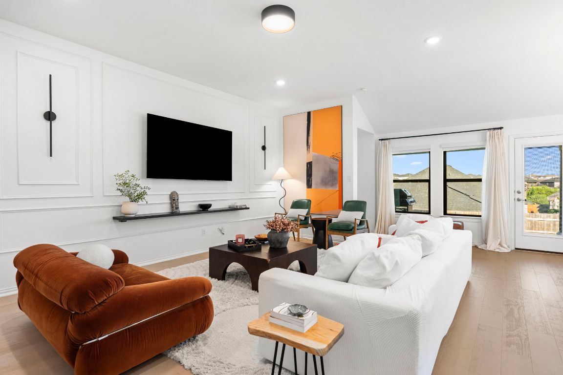 463 Oleander Loop Buda, TX 78610 - Photo 6 of 34 Living room featuring light wood-type flooring, recessed lighting, lofted ceiling, and a decorative wall