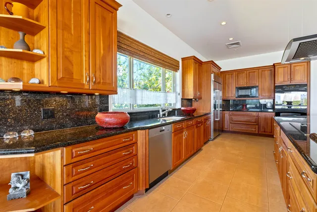 a kitchen with stainless steel appliances wooden cabinets a stove top oven a sink and dishwasher
