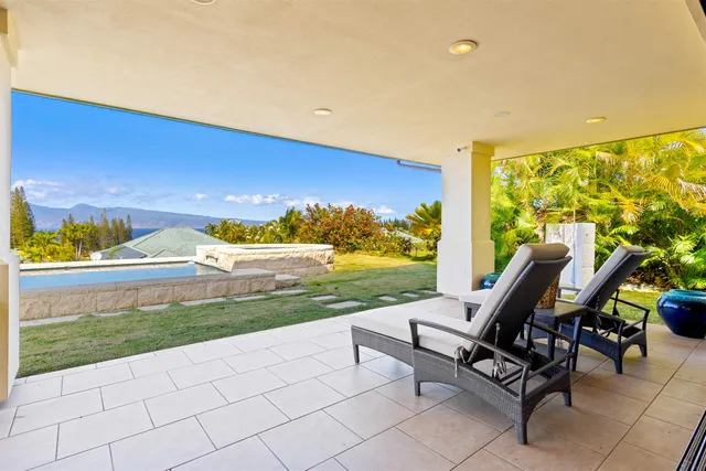 a roof deck with table and chairs and garden view