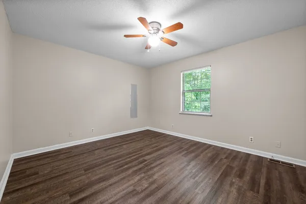 a view of an empty room with wooden floor
