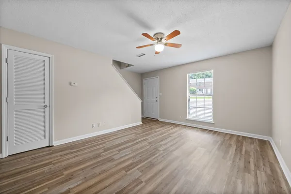 a view of a livingroom with wooden floor and a ceiling fan