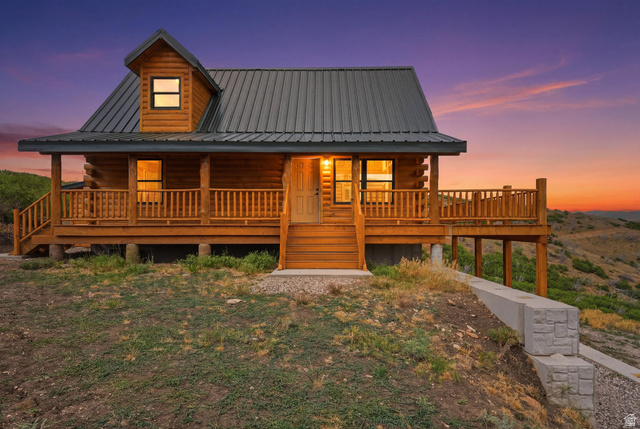 20 Q Puma Road Fairview, UT 84629 - Photo 1 of 27 Log cabin exterior featuring a covered porch with wood railings, a metal roof, and a dormer window