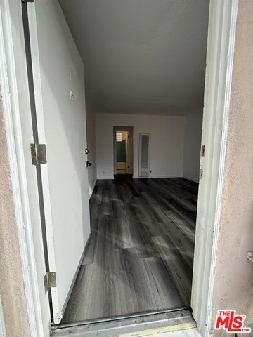 a view of empty room with kitchen and window