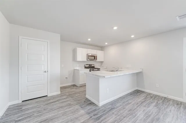 a view of kitchen with stainless steel appliances cabinets and wooden floor