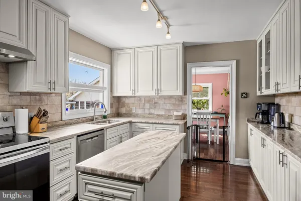 a kitchen with stainless steel appliances granite countertop a refrigerator a stove and a sink