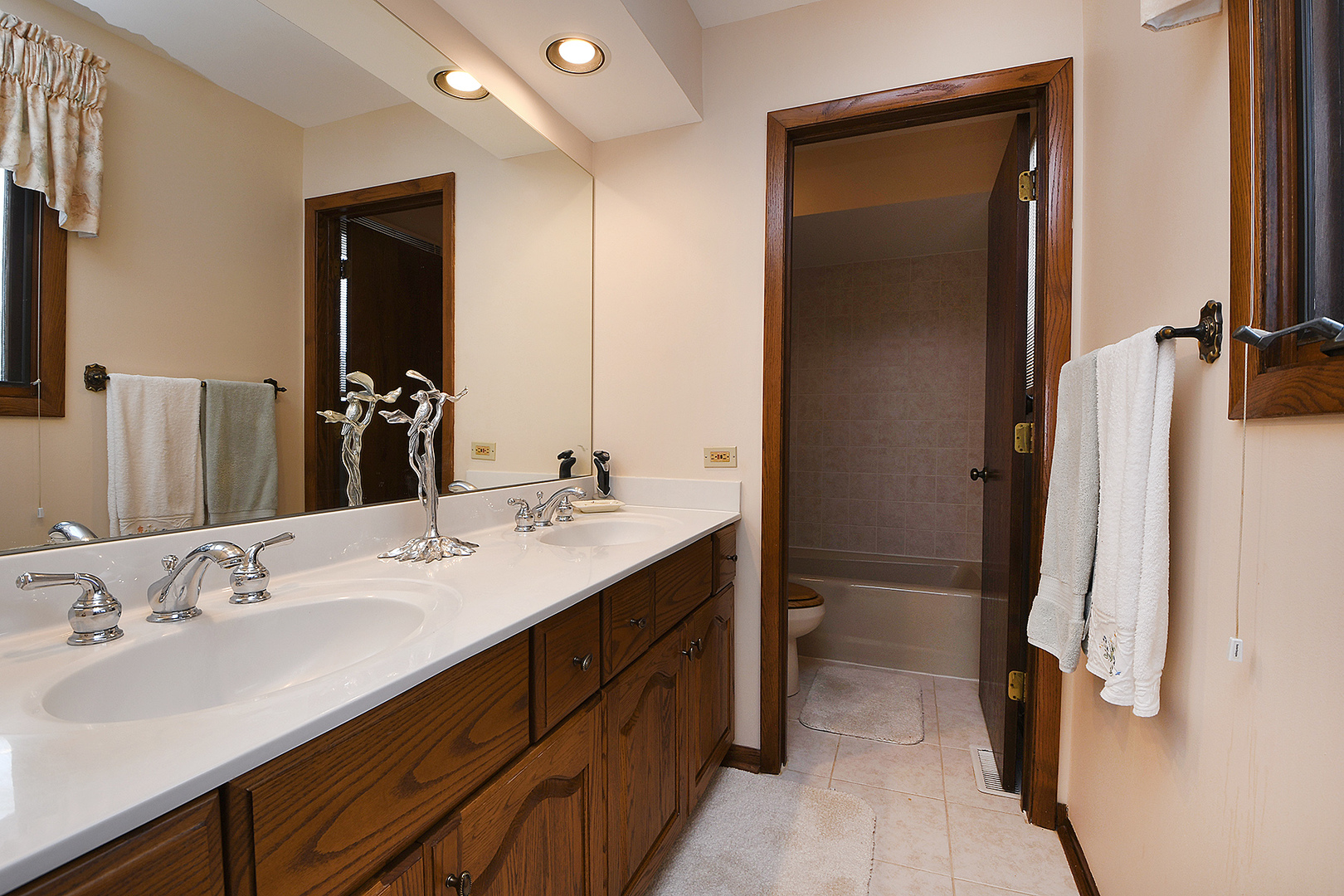 15 87th Street Burr Ridge, IL 60527 - Photo 24 of 34 a bathroom with a double vanity sink a toilet and a mirror