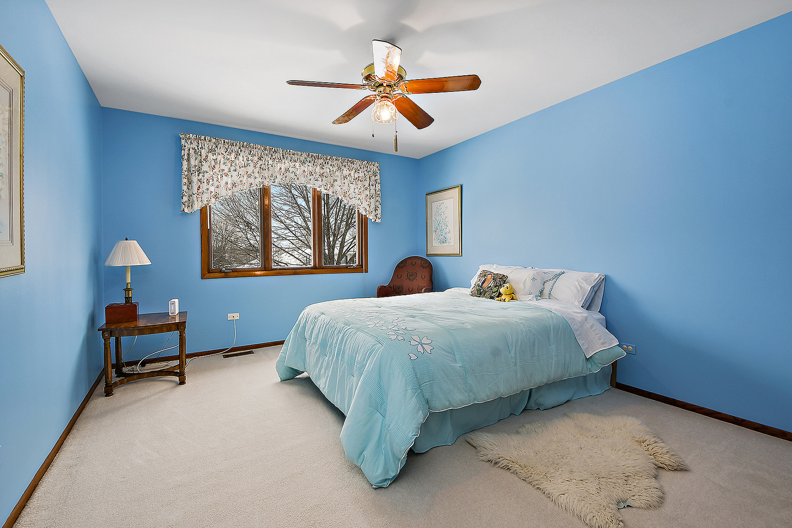 15 87th Street Burr Ridge, IL 60527 - Photo 25 of 34 a spacious bedroom with a bed and a chandelier