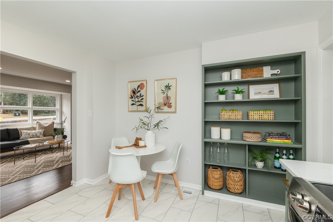 7714 Cherokee Road Richmond, VA 23225 - Photo 19 of 48 a dining room with furniture and a book shelf