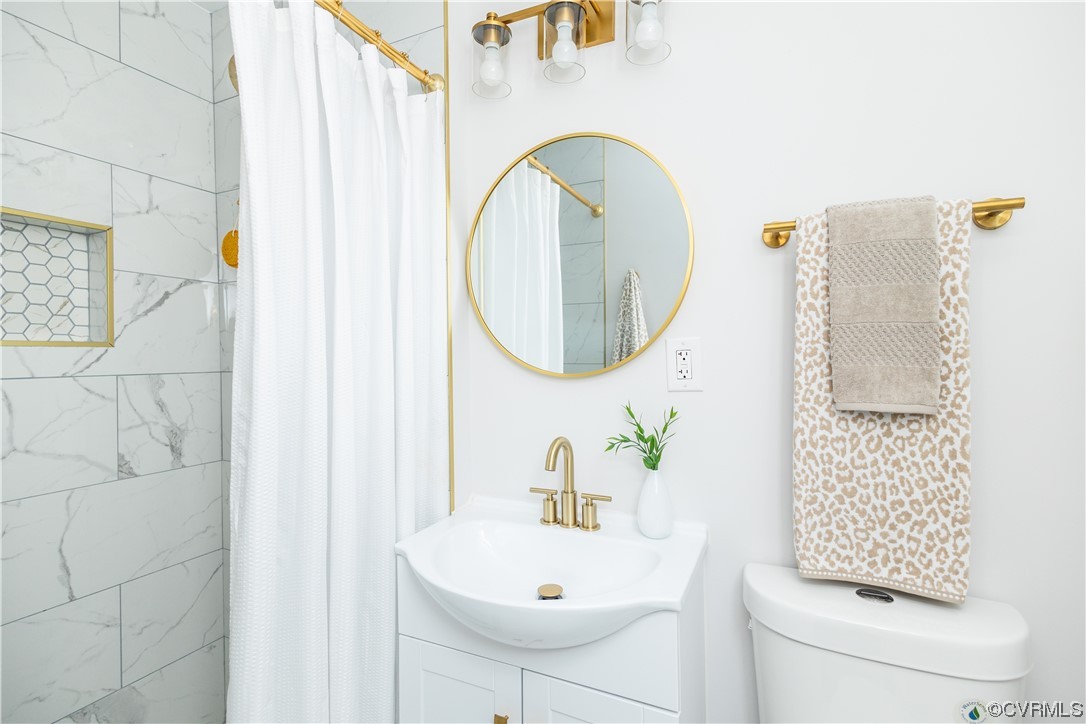 7714 Cherokee Road Richmond, VA 23225 - Photo 35 of 48 a bathroom with a sink a toilet and a mirror