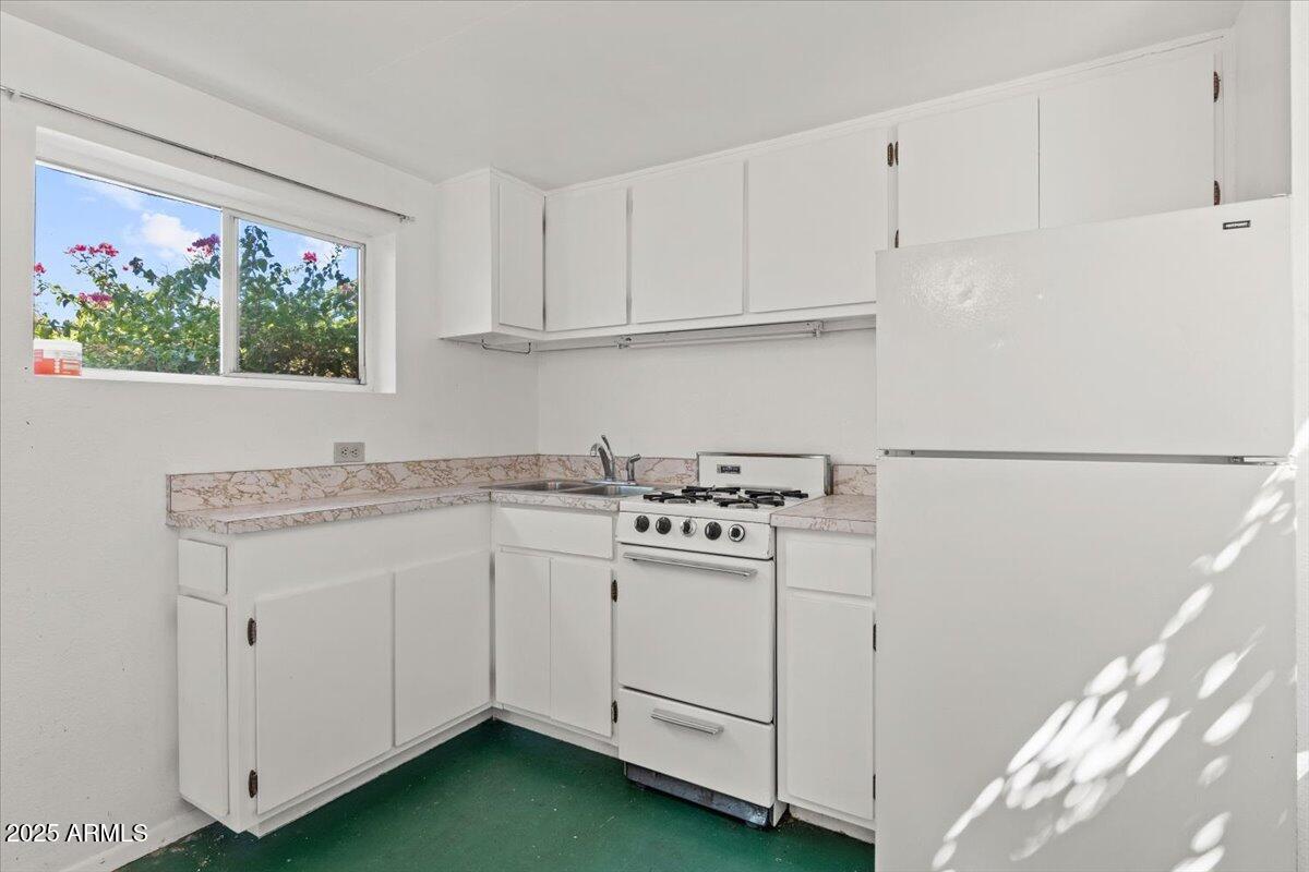 5702 East Camelback Road, Unit MEXICAN Phoenix, AZ 85251 - Photo 18 of 45 a kitchen with white cabinets sink and white appliances