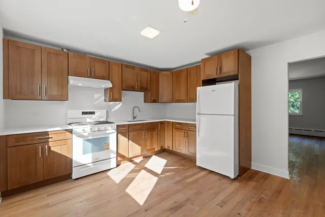a kitchen with a refrigerator a stove top oven a sink and cabinets