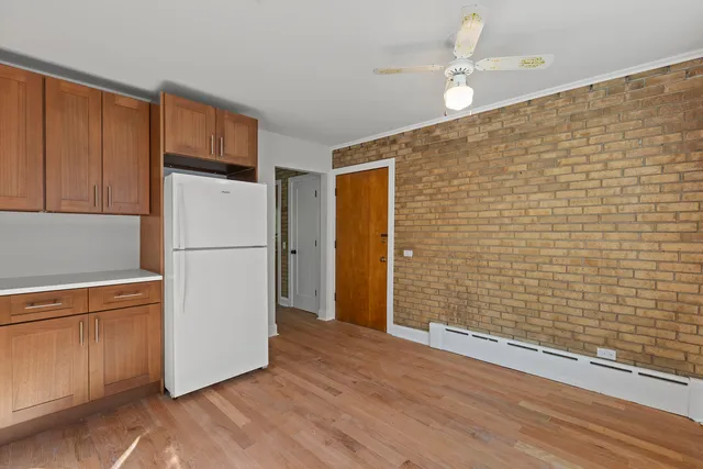 a view of a livingroom with wooden floor and a refrigerator