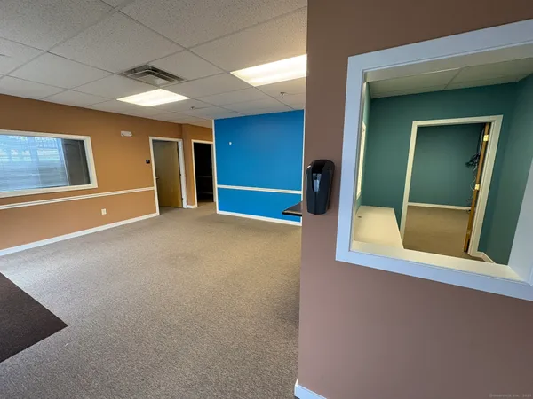 a view of an empty room with mirror on the wall