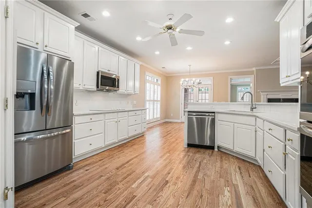 a kitchen with stainless steel appliances a refrigerator sink and microwave