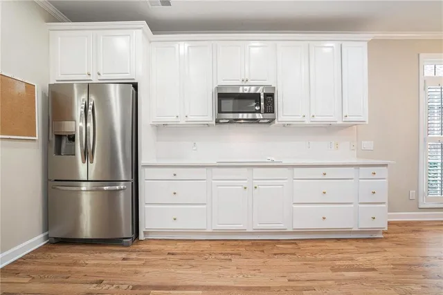 a kitchen with appliances a refrigerator and cabinets