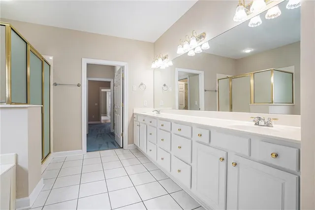 a spacious bathroom with a double vanity sink a mirror and a shower