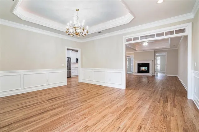a view of an empty room with wooden floor fireplace and a window