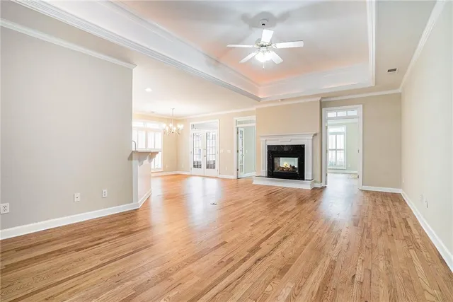 a view of an empty room with wooden floor and fireplace