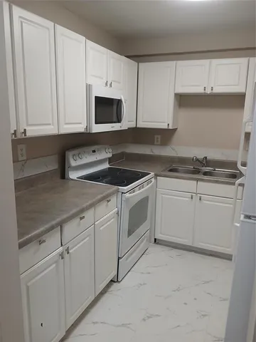 a white kitchen with granite top